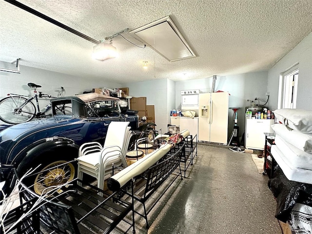 garage featuring concrete block wall, fridge, and white refrigerator with ice dispenser