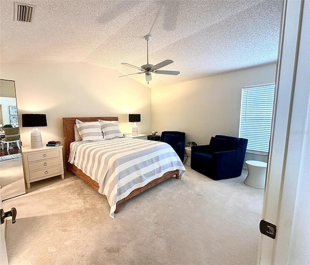 bedroom featuring lofted ceiling, light carpet, and a textured ceiling