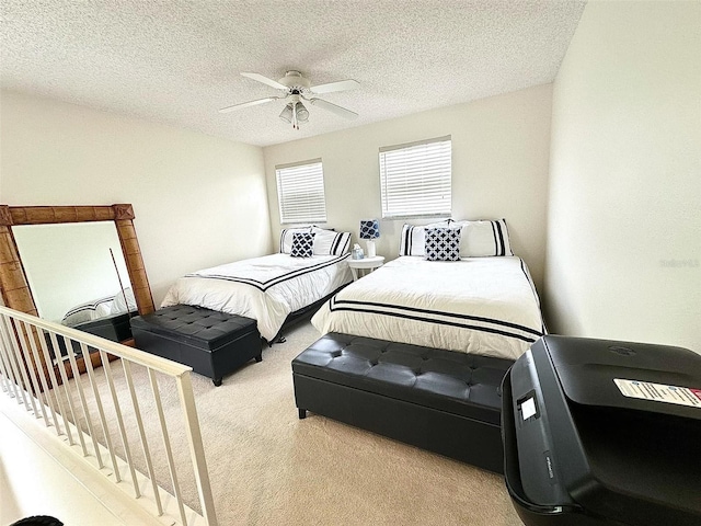 bedroom with light carpet, ceiling fan, and a textured ceiling