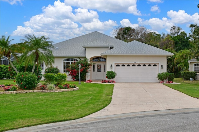 view of front of home with a garage and a front lawn