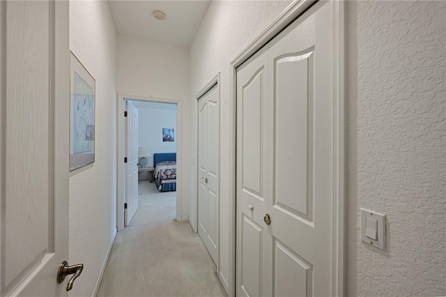 corridor featuring light colored carpet