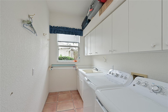 laundry area featuring cabinets, light tile patterned floors, sink, and washing machine and clothes dryer