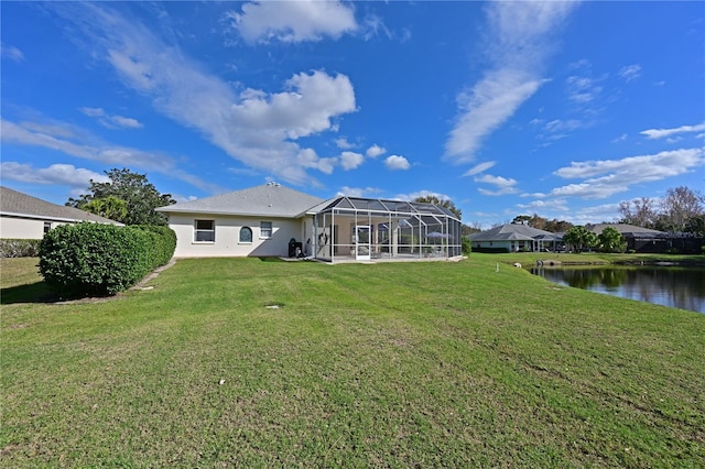 rear view of house featuring a lawn, glass enclosure, and a water view