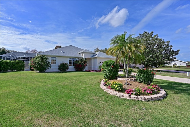 view of front facade with glass enclosure, driveway, and a front lawn