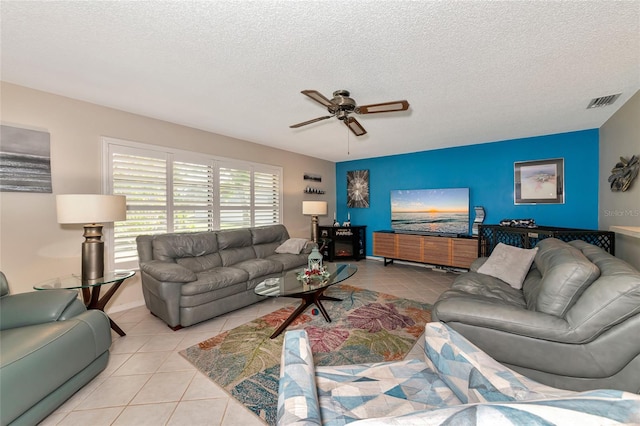 tiled living room featuring a textured ceiling and ceiling fan