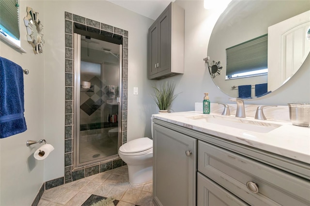 bathroom with vanity, toilet, and a shower with door