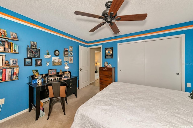 bedroom featuring carpet flooring, ceiling fan, a textured ceiling, and a closet