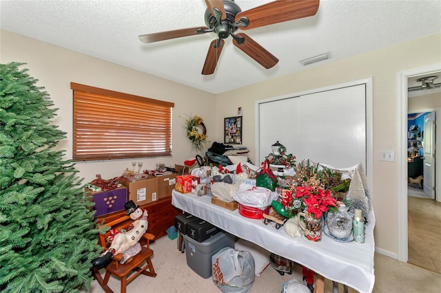 carpeted bedroom with ceiling fan and a textured ceiling