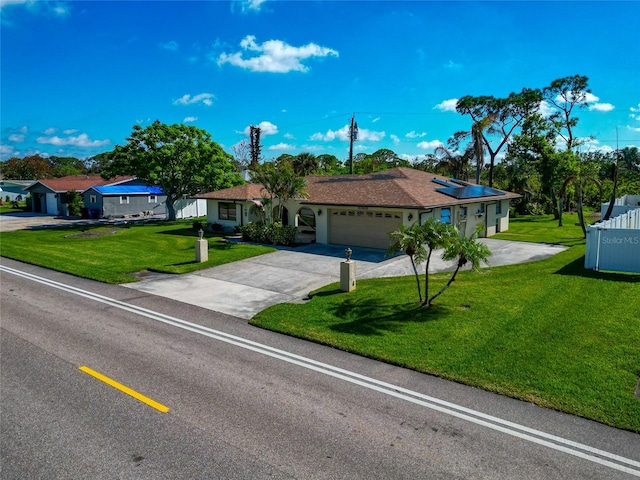 ranch-style home with solar panels, a garage, and a front yard