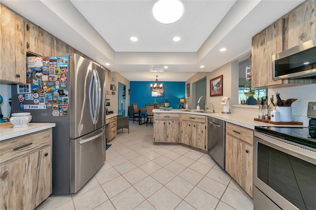 kitchen featuring stainless steel appliances, sink, decorative light fixtures, a chandelier, and light tile patterned flooring