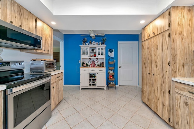 kitchen with ceiling fan, light tile patterned floors, and appliances with stainless steel finishes