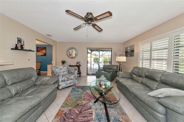 living room featuring a wealth of natural light, light tile patterned floors, a textured ceiling, and ceiling fan