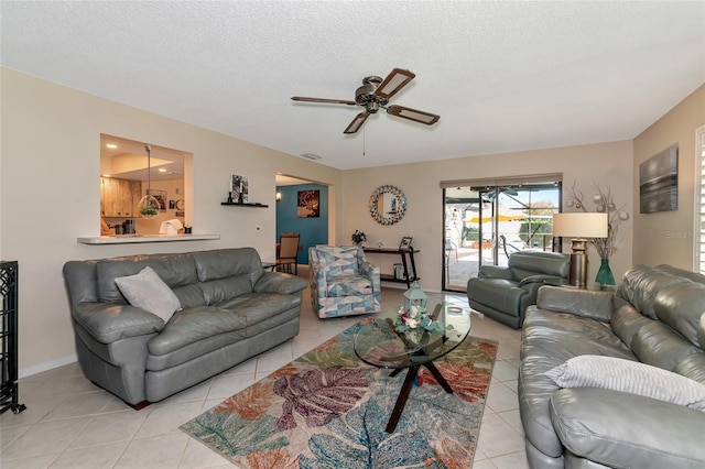 living room featuring light tile patterned floors, a textured ceiling, and ceiling fan