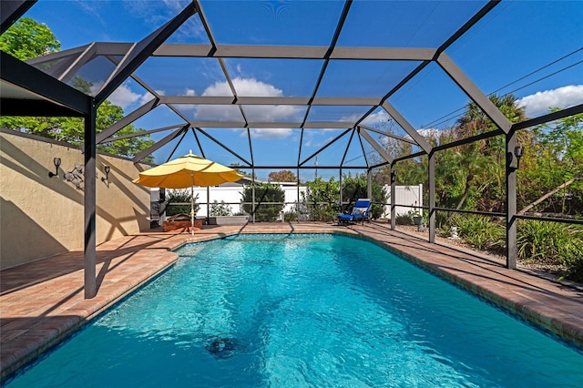 view of pool featuring glass enclosure and a patio area