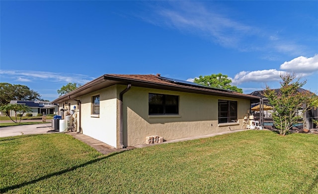 view of home's exterior with solar panels and a yard