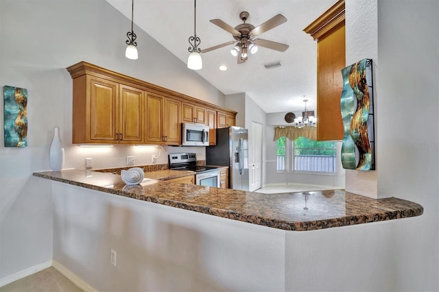 kitchen featuring hanging light fixtures, lofted ceiling, kitchen peninsula, and appliances with stainless steel finishes