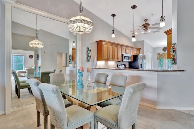 carpeted dining room featuring high vaulted ceiling and ceiling fan