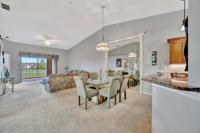 dining area featuring vaulted ceiling, light colored carpet, and ceiling fan