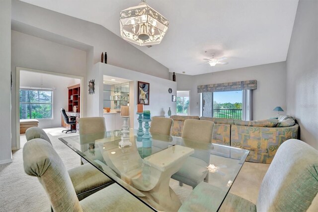 dining space featuring carpet flooring, ceiling fan, and vaulted ceiling