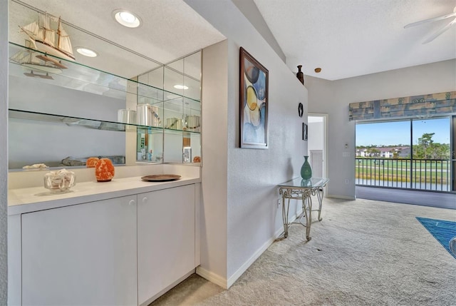 interior space featuring vanity, a textured ceiling, and ceiling fan