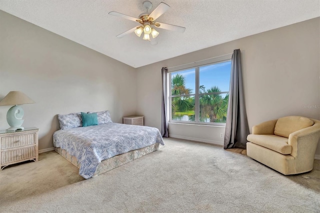 bedroom featuring a textured ceiling, light carpet, ceiling fan, and vaulted ceiling