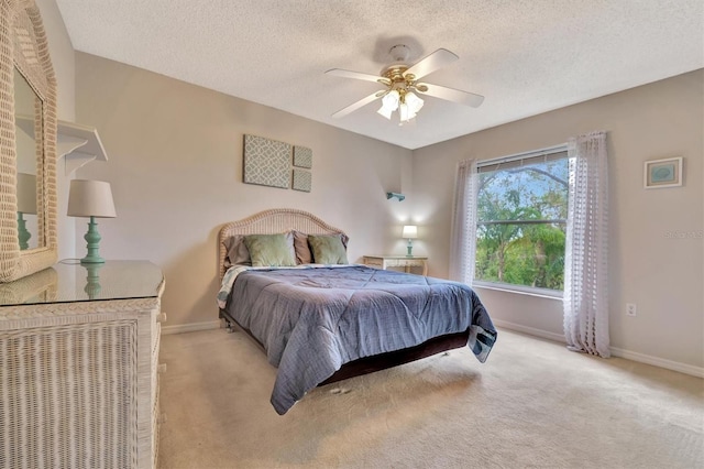 carpeted bedroom featuring a textured ceiling and ceiling fan