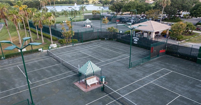 view of tennis court featuring a water view