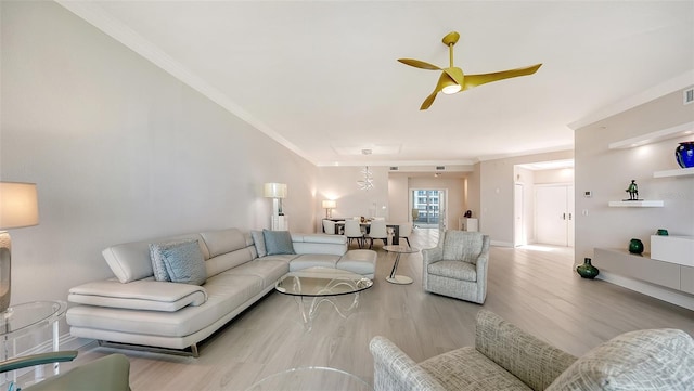 living room with ornamental molding, light hardwood / wood-style floors, and ceiling fan