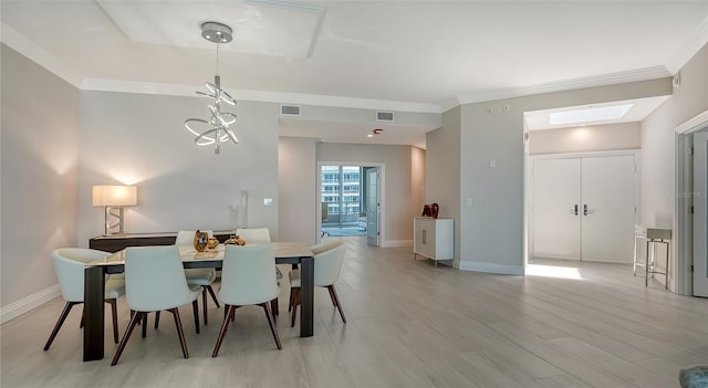 dining space featuring light hardwood / wood-style floors, a skylight, and crown molding