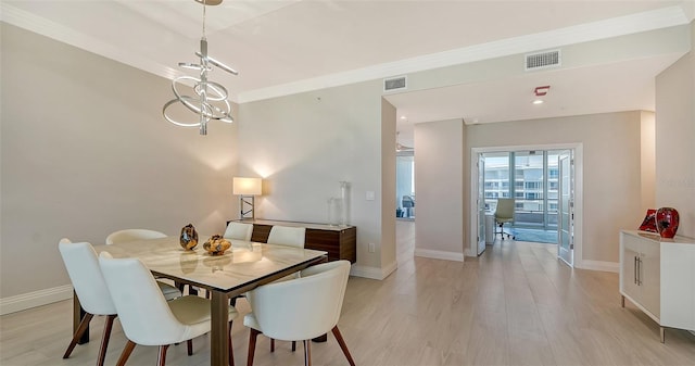 dining space featuring light hardwood / wood-style floors and crown molding