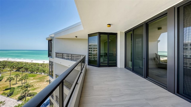 balcony with a water view and a beach view