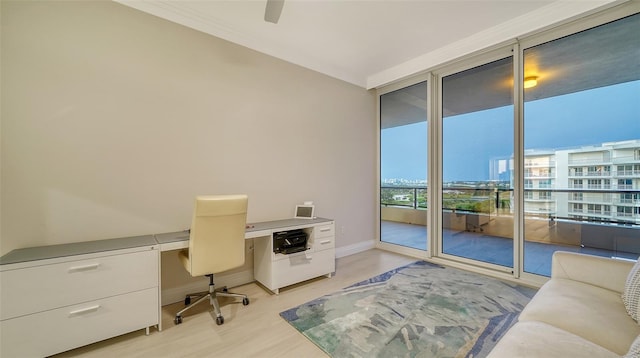 office area with expansive windows, ceiling fan, and light hardwood / wood-style floors