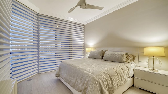 bedroom featuring ornamental molding, light hardwood / wood-style floors, and ceiling fan