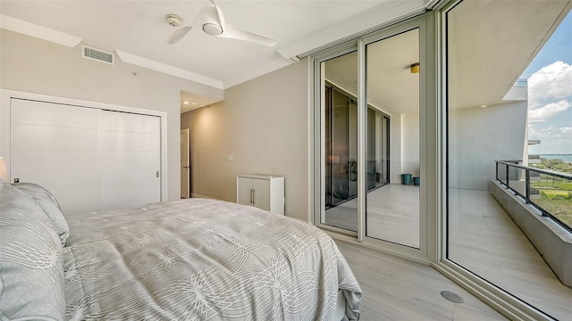 bedroom featuring ceiling fan, light hardwood / wood-style floors, access to exterior, and crown molding