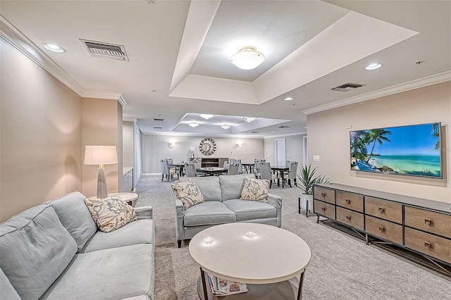 living room featuring light colored carpet, crown molding, and a tray ceiling