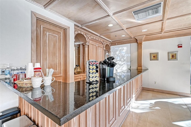 kitchen featuring kitchen peninsula, decorative columns, light tile patterned flooring, crown molding, and light brown cabinets