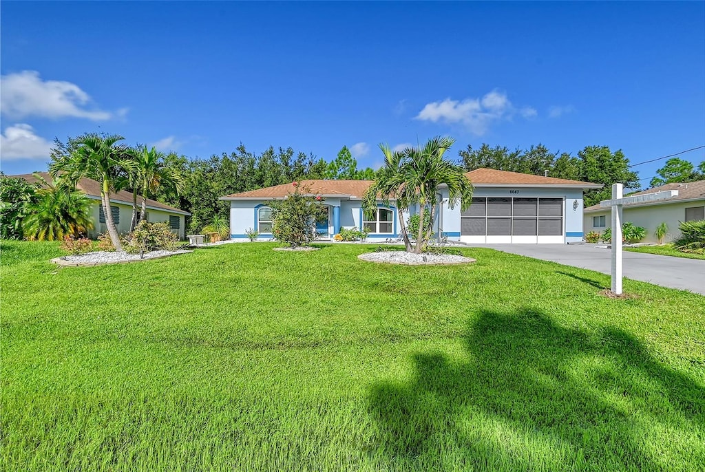 ranch-style house featuring a front yard and a garage