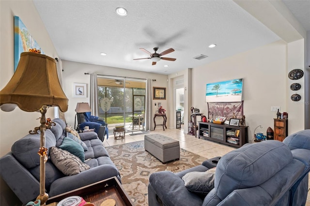 tiled living room with ceiling fan and a textured ceiling