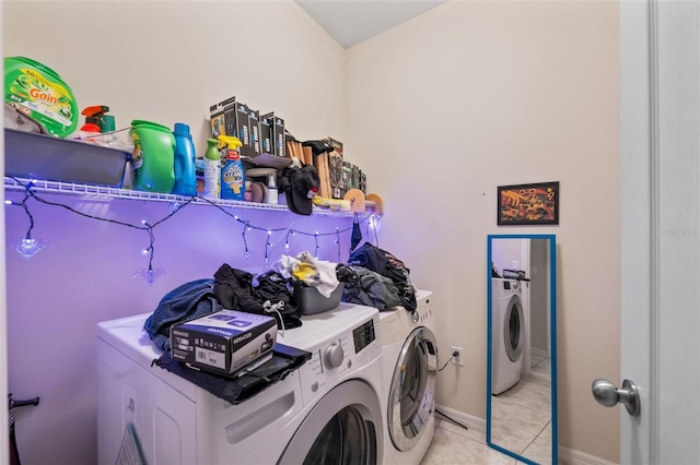 clothes washing area featuring washer and dryer and light tile patterned floors