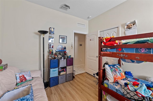 bedroom with light hardwood / wood-style floors and a textured ceiling