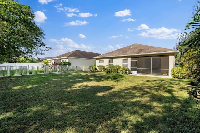 back of house featuring a lawn and a sunroom