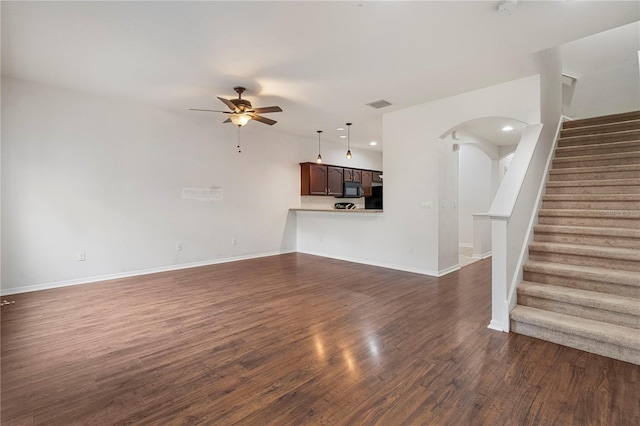 unfurnished living room featuring dark hardwood / wood-style flooring and ceiling fan