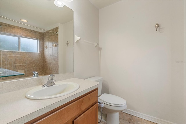 bathroom featuring tile patterned floors, vanity, tiled shower, and toilet