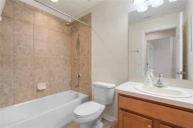 full bathroom featuring vanity, tiled shower / bath combo, and toilet