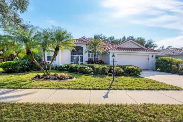 mediterranean / spanish-style house featuring stucco siding, a tile roof, concrete driveway, a front yard, and a garage