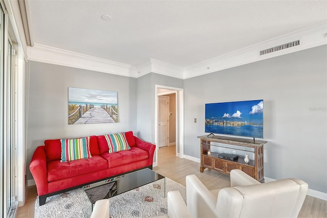 living room with ornamental molding and light hardwood / wood-style flooring