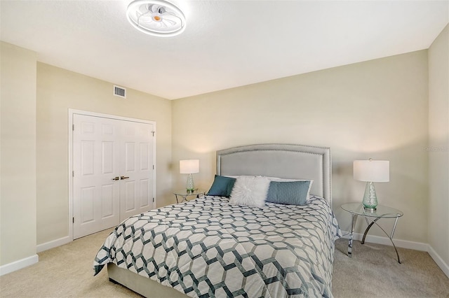 bedroom with light carpet and a closet