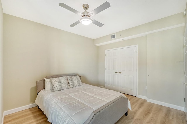 bedroom featuring ceiling fan, a closet, and light wood-type flooring