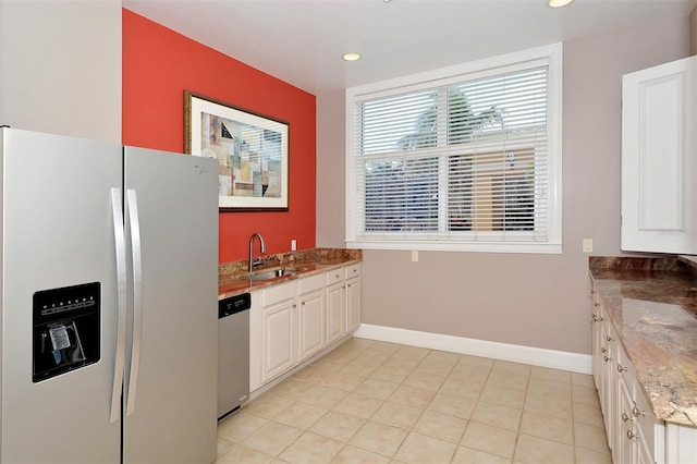 kitchen with light tile patterned flooring, white refrigerator with ice dispenser, white cabinetry, sink, and dishwasher