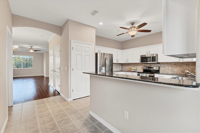 kitchen with white cabinetry, sink, kitchen peninsula, light wood-type flooring, and stainless steel appliances